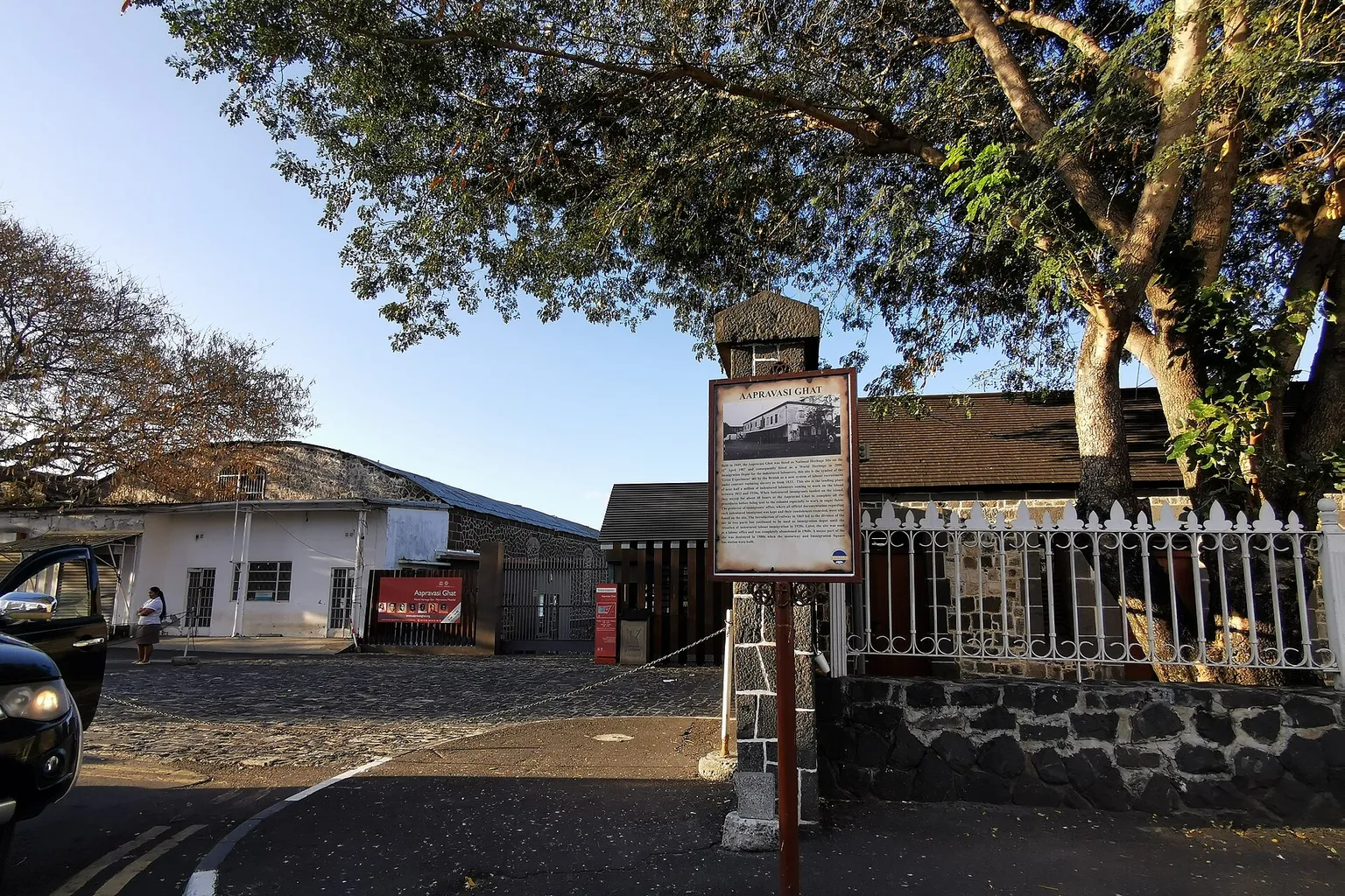 Entrée de l'Aapravasi Ghat à Port-Louis, panneau d'information et murs de pierre noire