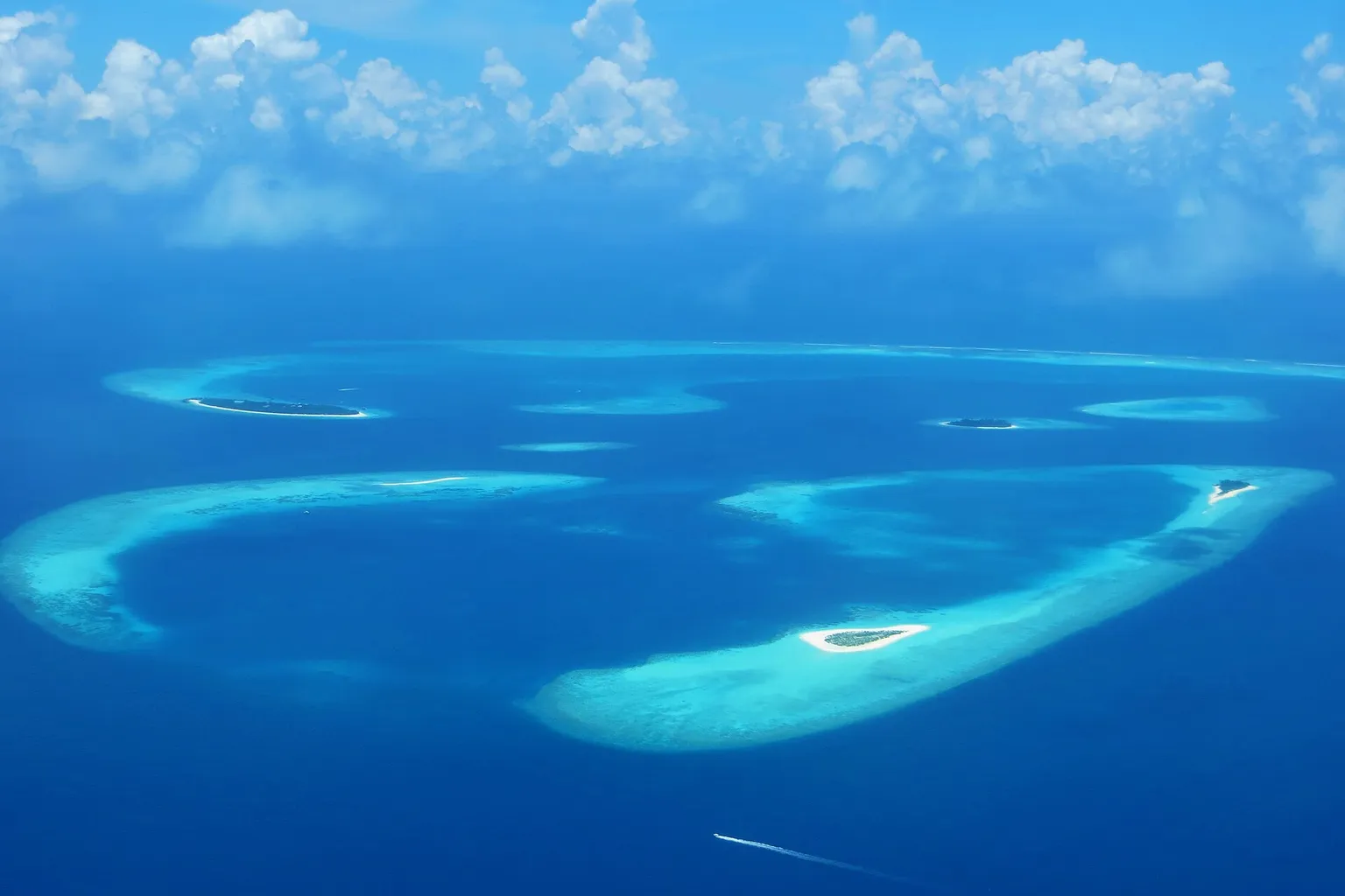Îlots de sable entourés de lagons turquoise dans l'atoll de Baa, vus du ciel