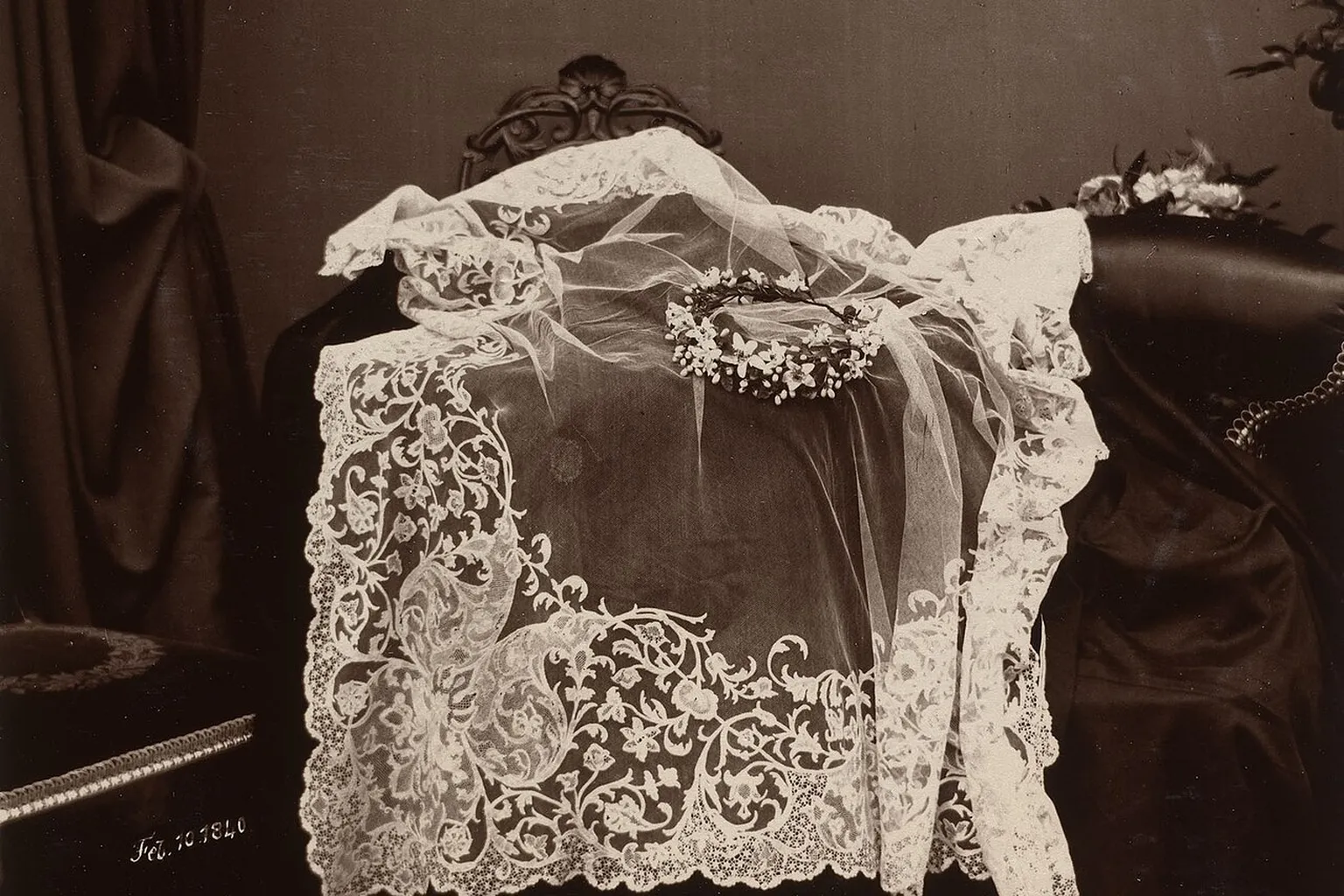 Voile de dentelle de Honiton et couronne de fleurs d'oranger posés sur un fauteuil, photographie ancienne en sépia