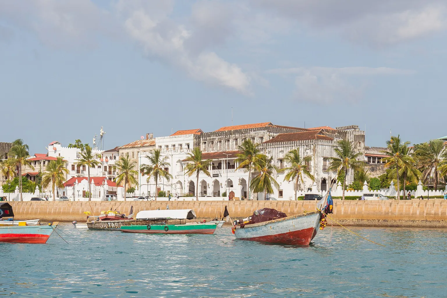 Le front de mer de Stone Town à Zanzibar, avec ses façades blanches, ses palmiers et ses barques de pêche